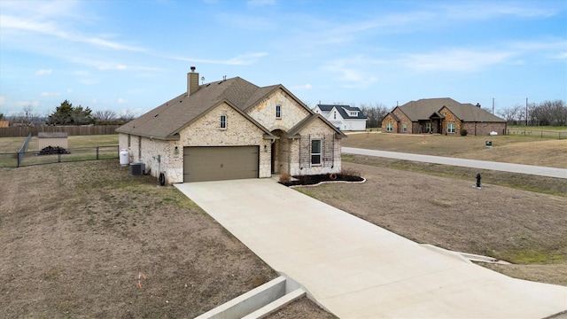 french provincial home featuring a garage, central AC unit, and a front lawn