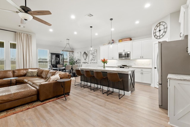 living room with ceiling fan and light wood-type flooring