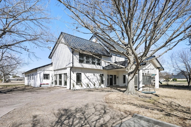 exterior space with aphalt driveway and metal roof