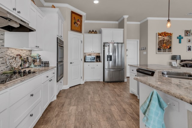 kitchen with white cabinetry, sink, hanging light fixtures, light stone counters, and stainless steel appliances