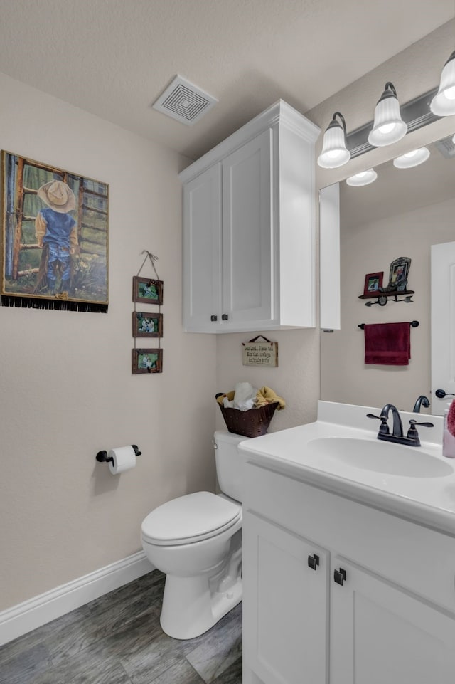 7728 County Road 1205, Rio Vista, TX 76093 - bathroom featuring toilet, vanity, baseboards, and wood finished floors