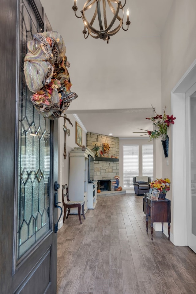 entryway featuring hardwood / wood-style flooring, a fireplace, and an inviting chandelier