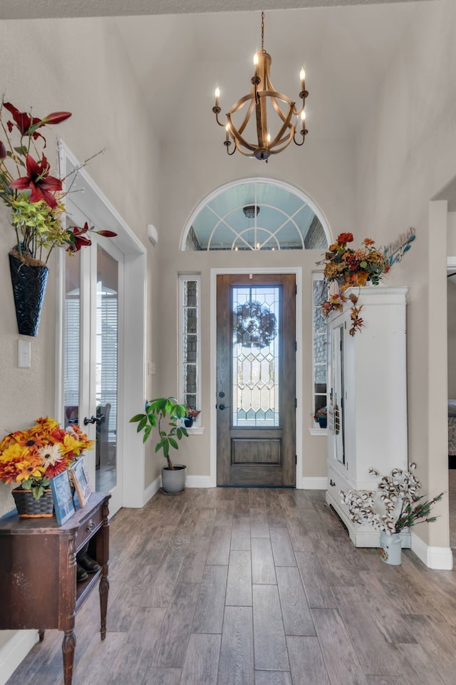 7728 County Road 1205, Rio Vista, TX 76093 - foyer with a chandelier, wood finished floors, high vaulted ceiling, and baseboards