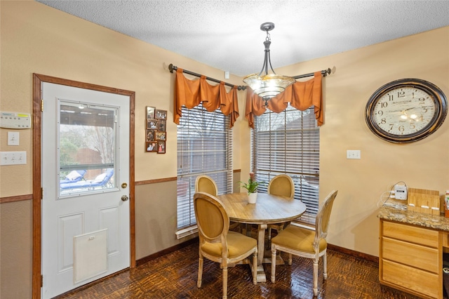 dining room with an inviting chandelier and a textured ceiling