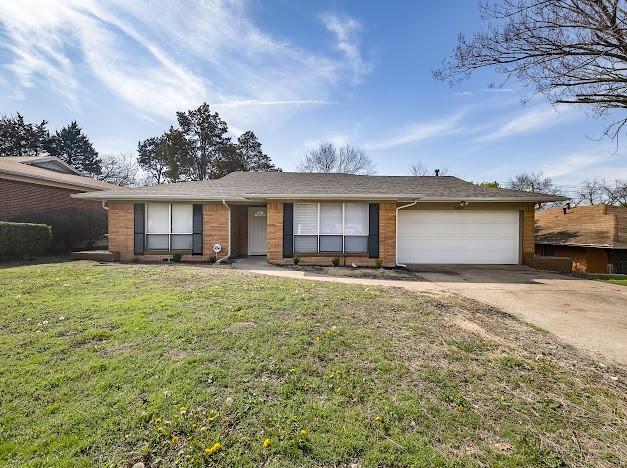 ranch-style house with a garage and a front lawn