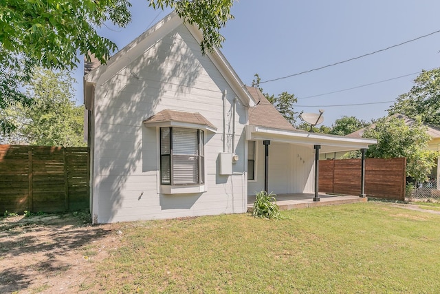 rear view of property featuring a lawn