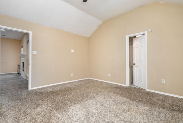 empty room featuring carpet floors, vaulted ceiling, and ceiling fan