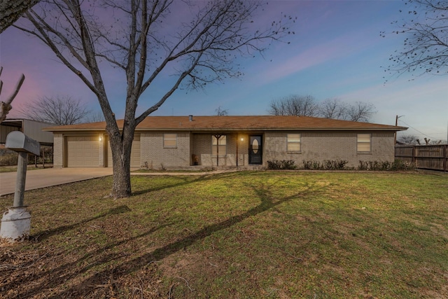 ranch-style house featuring a garage and a lawn