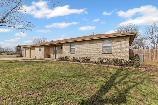 ranch-style home with cooling unit, a garage, and a front lawn