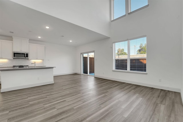 unfurnished living room with light hardwood / wood-style floors and a healthy amount of sunlight