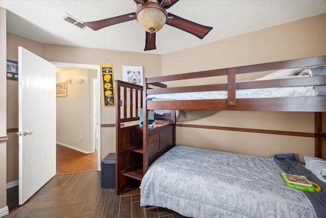 bedroom with visible vents, a textured ceiling, and baseboards