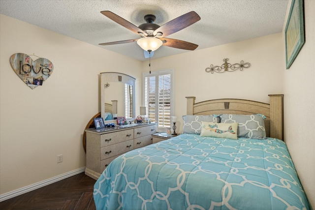 bedroom with a textured ceiling, ceiling fan, and baseboards