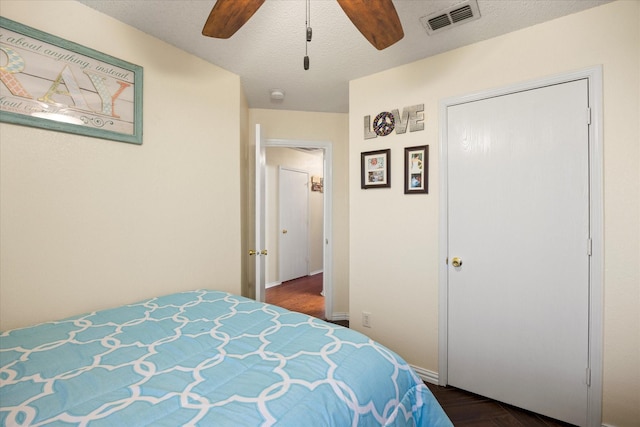 bedroom with a textured ceiling, ceiling fan, and visible vents