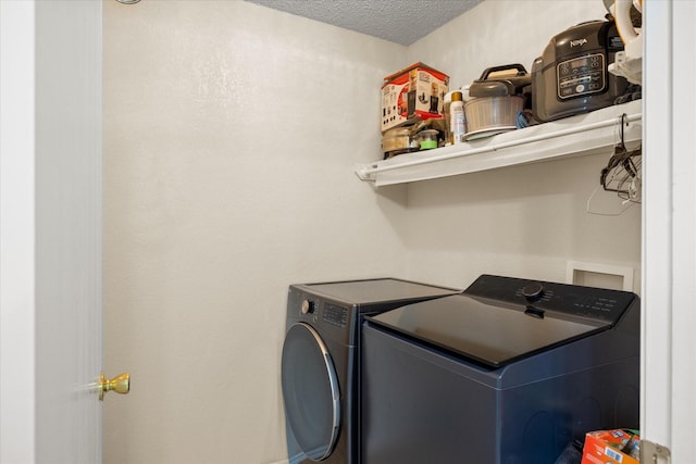 washroom with washing machine and dryer, laundry area, and a textured ceiling