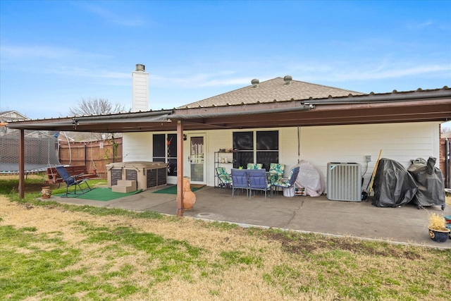 back of property featuring central air condition unit, a patio area, a trampoline, and fence