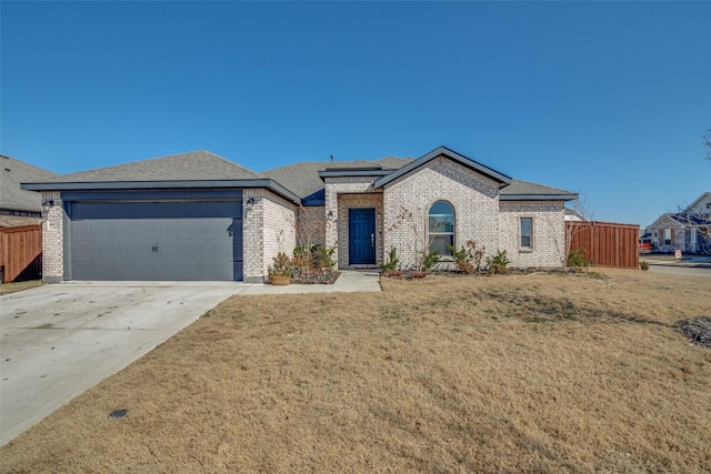 view of front facade featuring a garage, brick siding, fence, concrete driveway, and a front yard