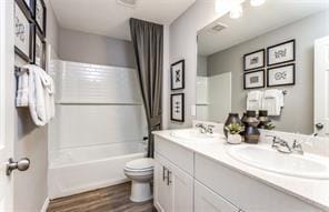 full bathroom with shower / tub combo, vanity, hardwood / wood-style flooring, and toilet