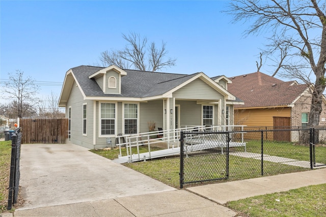 view of front of property featuring a fenced front yard, covered porch, roof with shingles, a gate, and a front lawn