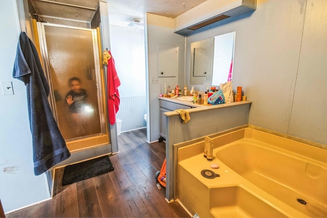 full bathroom with separate shower and tub, vanity, toilet, and hardwood / wood-style floors