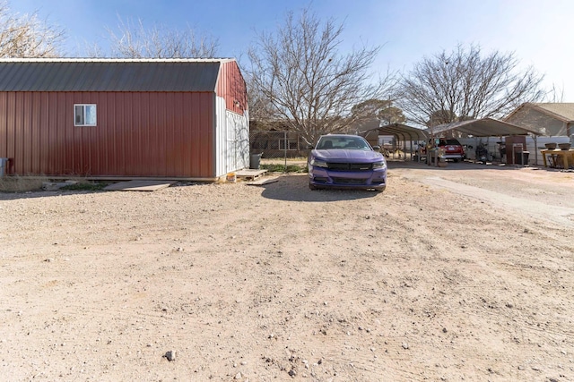 view of yard featuring a carport and an outbuilding