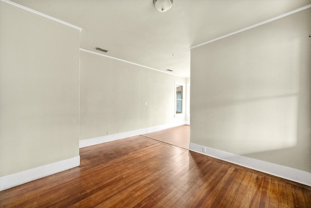 empty room with hardwood / wood-style flooring and ornamental molding