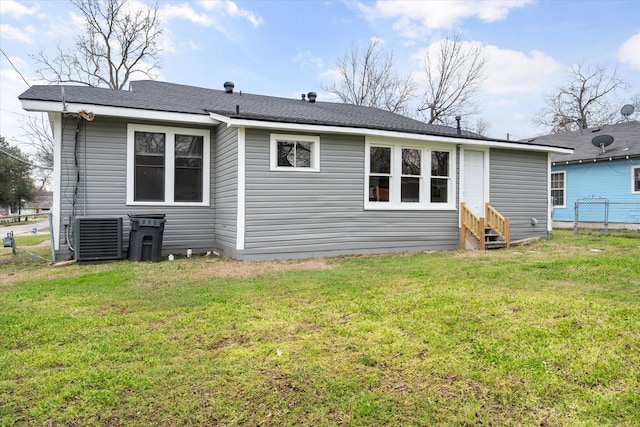 back of property featuring central AC and a yard