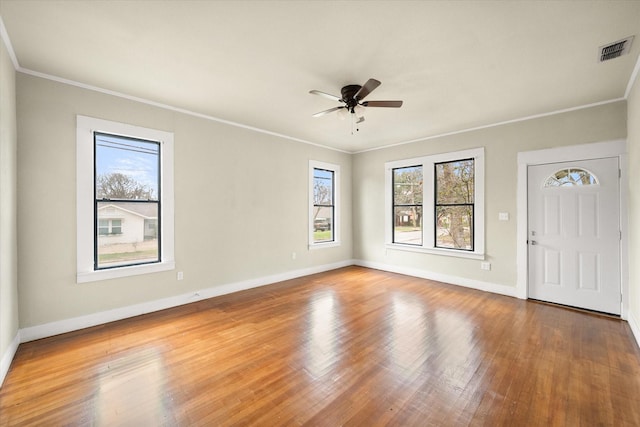 1402 W 1st Ave, Corsicana, TX 75110 - foyer entrance featuring visible vents, baseboards, ornamental molding, wood finished floors, and a ceiling fan