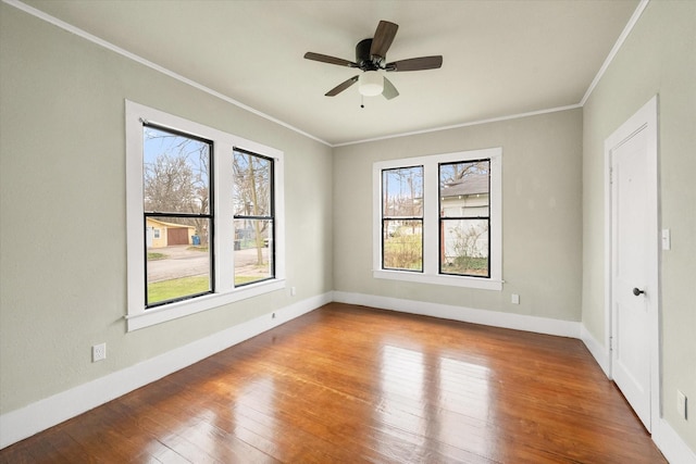 empty room featuring hardwood / wood-style floors, ornamental molding, and ceiling fan