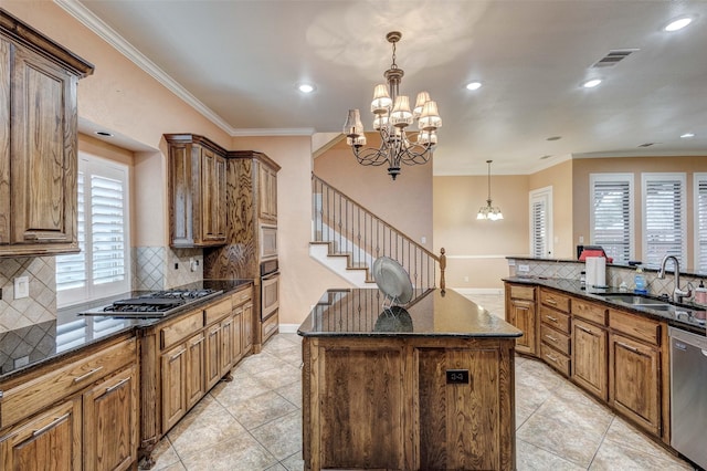 kitchen with a kitchen island, pendant lighting, sink, a notable chandelier, and stainless steel appliances