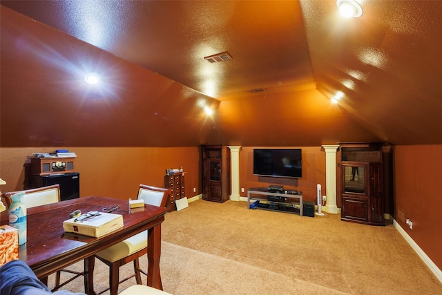 cinema room with lofted ceiling, decorative columns, a textured ceiling, and carpet flooring