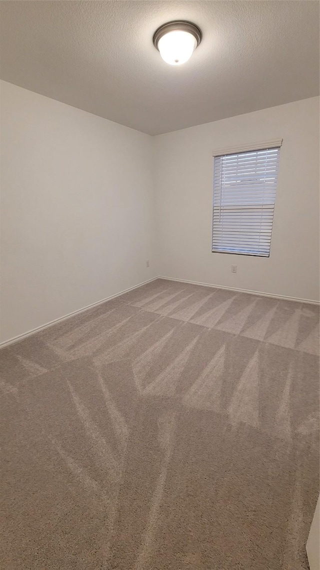 carpeted empty room with a textured ceiling