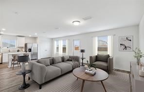 living room with light hardwood / wood-style floors and a healthy amount of sunlight