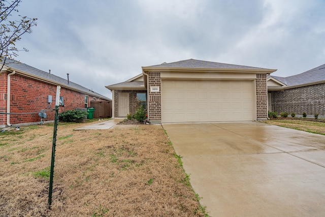 view of front of property featuring a garage, a front yard, concrete driveway, and brick siding