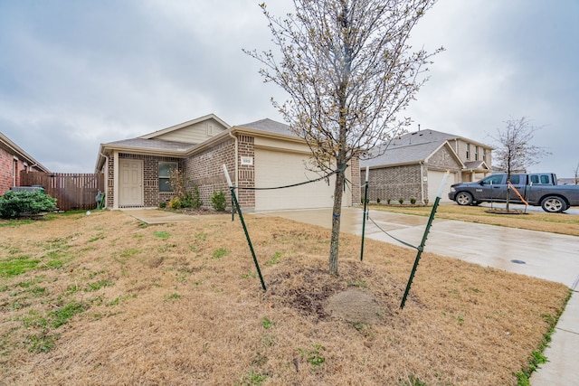 ranch-style home featuring a garage, concrete driveway, brick siding, and fence