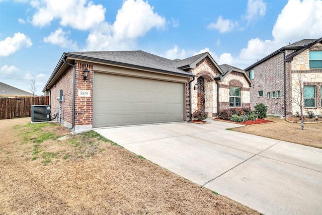 single story home with central AC, a garage, and a front lawn