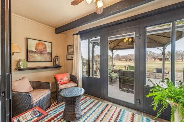 doorway to outside with ceiling fan and beamed ceiling