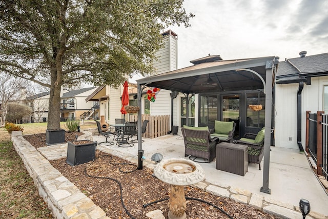 view of patio featuring a gazebo and an outdoor living space with a fire pit