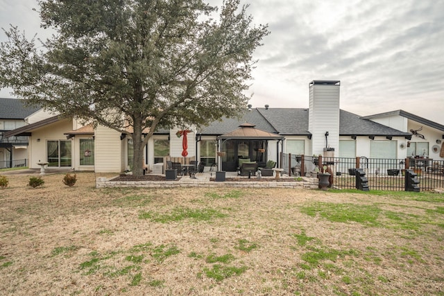 back of house with a gazebo, a patio area, and a lawn