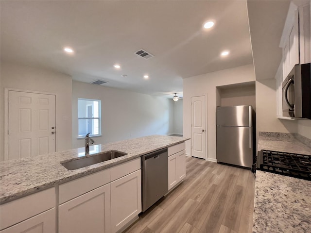 231 Marsh Ln, Princeton, TX 75407 - kitchen featuring sink, white cabinetry, light wood-type flooring, stainless steel appliances, and light stone countertops