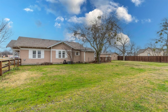 back of property featuring a yard, crawl space, and a fenced backyard