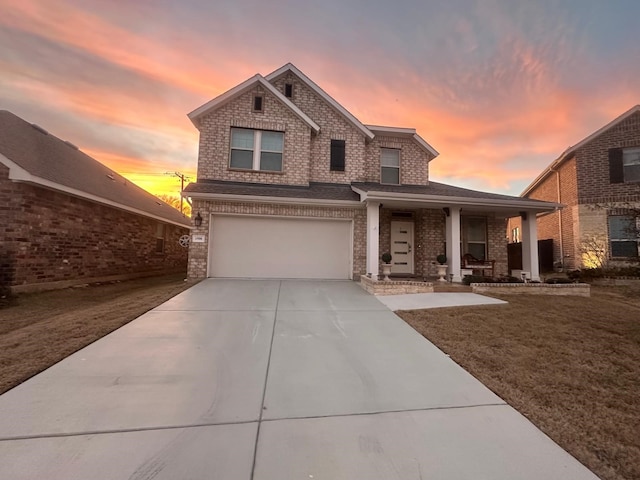 view of front property featuring a garage, covered porch, and a lawn