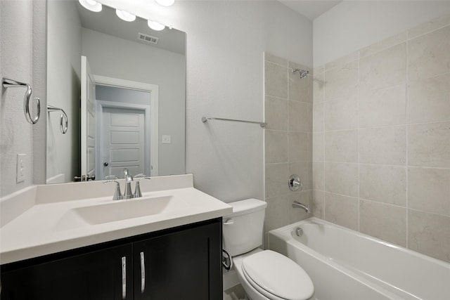 full bathroom with tiled shower / bath, vanity, and toilet