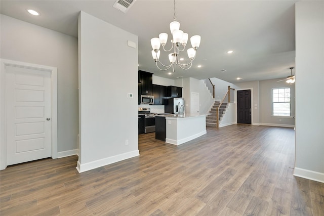 unfurnished living room with dark hardwood / wood-style floors and ceiling fan with notable chandelier