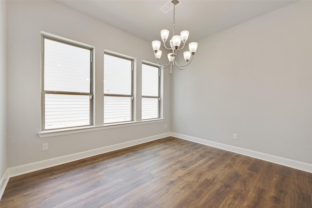 unfurnished room featuring a notable chandelier and dark hardwood / wood-style flooring