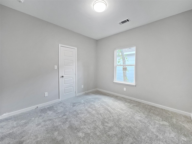 carpeted spare room with baseboards and visible vents