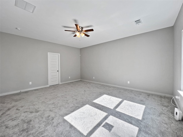 carpeted empty room featuring baseboards, visible vents, and ceiling fan