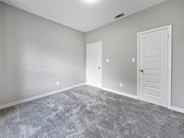 empty room featuring visible vents, baseboards, and carpet