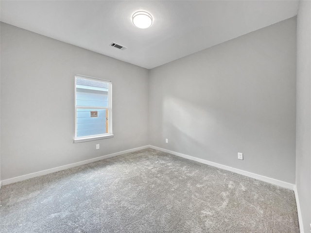 carpeted spare room with visible vents and baseboards