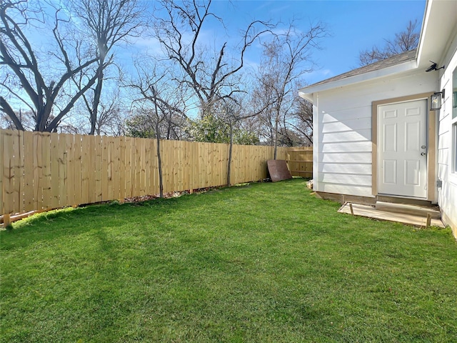 view of yard with a fenced backyard and entry steps