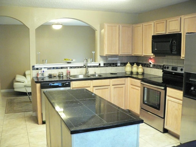 kitchen with light tile patterned flooring, sink, a center island, stainless steel appliances, and light brown cabinets